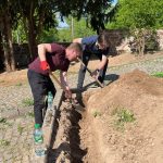 Zwei Männer heben einen GRaben aus